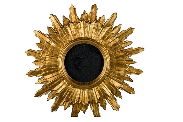 Round mirror in gilded wood